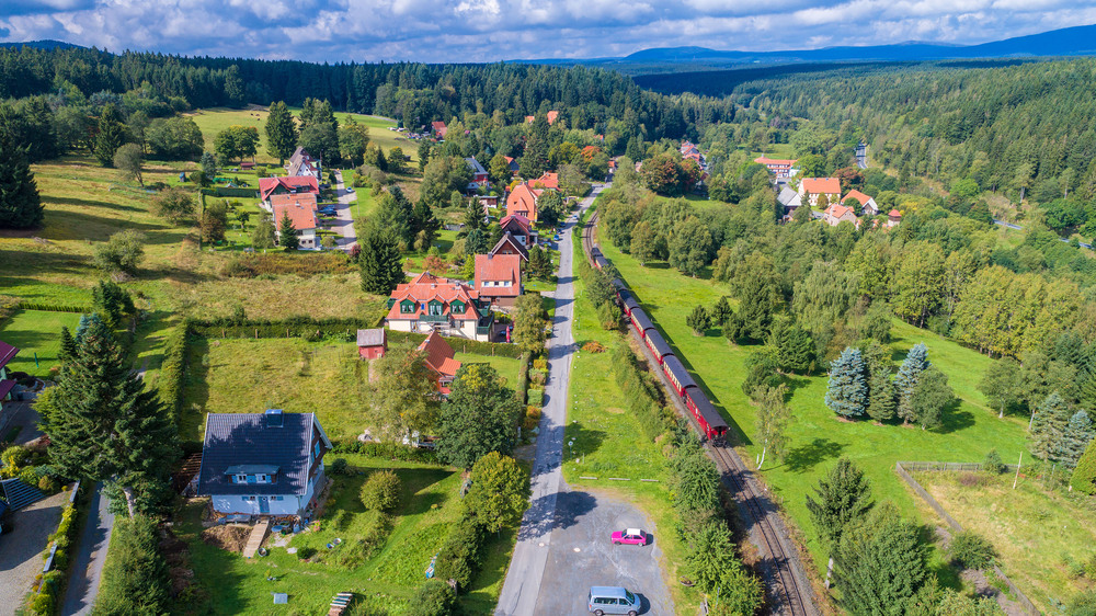 Das Luftbild von Sorge zeigt einen freundlichen Harzort mit Ausblick zum Brocken. Foto: DJD/Rübeländer Tropfsteinhöhlen/Jan Reichel